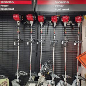 Six Honda string trimmers on display at a store.